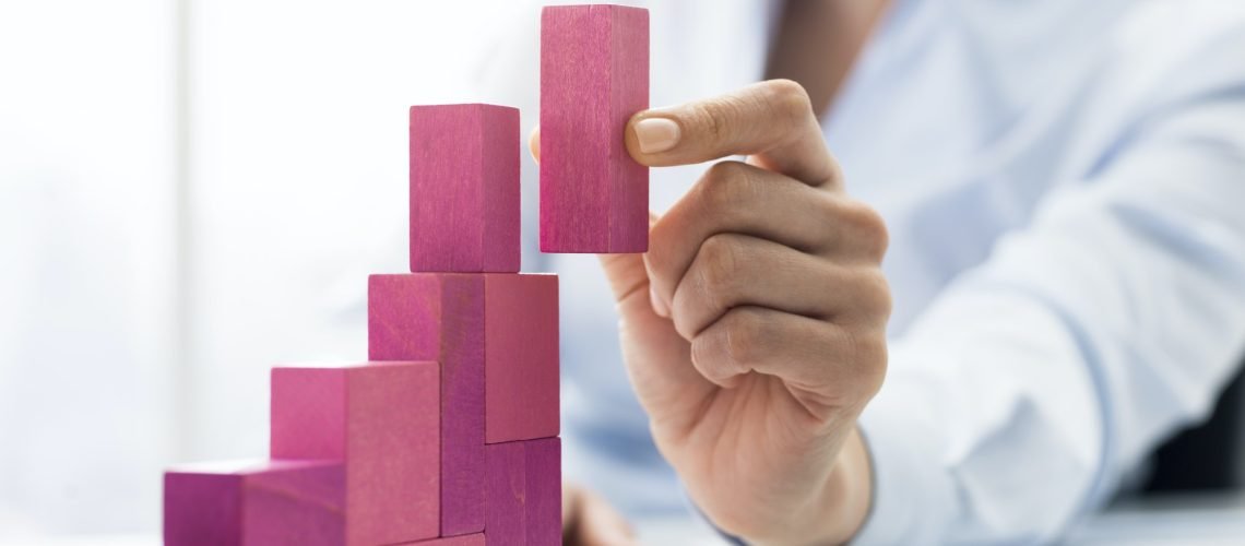 Businesswoman building a growing financial chart Businesswoman building a growing financial chart
